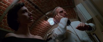 Movie still from “Mission: Impossible” (1996), directed by Brian De Palma – A man and a woman are standing in front of a brick wall; Close Up shot, Low angle