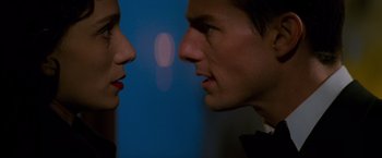 Movie still from “Mission: Impossible” (1996), directed by Brian De Palma – A man and a woman face to face in front of a blue background; Close Up shot, Over the shoulder angle