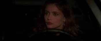 Movie still from “Mission: Impossible” (1996), directed by Brian De Palma – A woman sitting in the driver's seat of a car; Close Up shot, Over the shoulder angle
