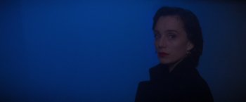 Movie still from “Mission: Impossible” (1996), directed by Brian De Palma – A woman in a black jacket is looking at the camera; Close Up shot, Low angle