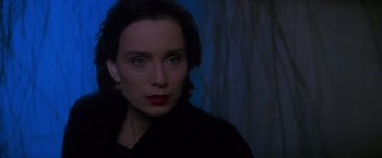 Movie still from “Mission: Impossible” (1996), directed by Brian De Palma – A person wearing a black shirt; Close Up shot, Over the shoulder angle