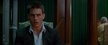 Movie still from “Mission: Impossible” (1996), directed by Brian De Palma – A person wearing a suit and tie; Close Up shot, Over the shoulder angle