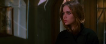 Movie still from “Mission: Impossible” (1996), directed by Brian De Palma – A beautiful young woman with long brown hair and blue eyes; Close Up shot, Over the shoulder angle