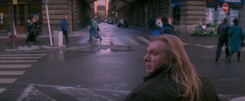 Movie still from “Mission: Impossible” (1996), directed by Brian De Palma – A man standing on the side of a street; Medium shot, Over the shoulder angle