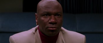 Movie still from “Mission: Impossible” (1996), directed by Brian De Palma – A man with a bald head wearing a jacket; Close Up shot, High angle