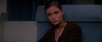 Movie still from “Mission: Impossible” (1996), directed by Brian De Palma – A woman sitting on a train looking at the camera; Close Up shot, Over the shoulder angle