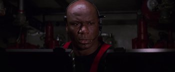 Movie still from “Mission: Impossible” (1996), directed by Brian De Palma – A man with a headset is looking at the camera; Close Up shot, Low angle