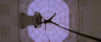 Movie still from “Mission: Impossible” (1996), directed by Brian De Palma – A man hanging from a rope in a building; Wide shot, Low angle