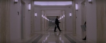 Movie still from “Mission: Impossible” (1996), directed by Brian De Palma – A man in a suit walking down a hall way; Extreme Wide shot, Low angle