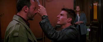 Movie still from “Mission: Impossible” (1996), directed by Brian De Palma – A man with a beard and a leather jacket is looking at another man's face; Close Up shot, Over the shoulder angle