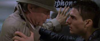 Movie still from “Mission: Impossible” (1996), directed by Brian De Palma – A man wearing a hat and a jacket is talking to another man; Close Up shot, Over the shoulder angle
