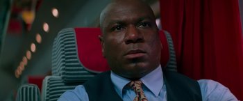 Movie still from “Mission: Impossible” (1996), directed by Brian De Palma – A man in a vest and tie sitting in a car; Close Up shot, Low angle