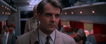 Movie still from “Mission: Impossible” (1996), directed by Brian De Palma – A person wearing a suit and tie; Close Up shot, Low angle