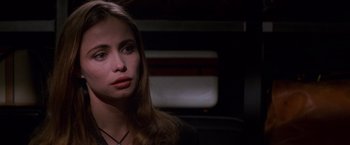 Movie still from “Mission: Impossible” (1996), directed by Brian De Palma – A woman with long brown hair wearing a black shirt; Close Up shot, Over the shoulder angle