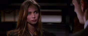 Movie still from “Mission: Impossible” (1996), directed by Brian De Palma – A beautiful young woman with long brown hair and blue eyes; Close Up shot, Over the shoulder angle