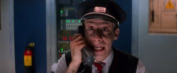 Movie still from “Mission: Impossible” (1996), directed by Brian De Palma – A man wearing a hat talking on a phone; Close Up shot, Low angle