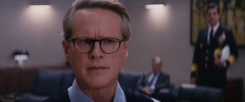 Movie still from “Mission: Impossible - Dead Reckoning Part One” (2023), directed by Christopher McQuarrie – A person wearing a suit and glasses; Close Up shot, Over the shoulder angle