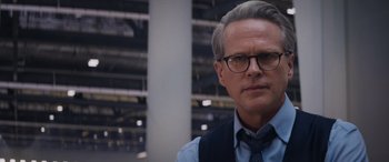 Movie still from “Mission: Impossible - Dead Reckoning Part One” (2023), directed by Christopher McQuarrie – A person wearing glasses and a tie; Close Up shot, Over the shoulder angle