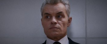 Movie still from “Mission: Impossible - Dead Reckoning Part One” (2023), directed by Christopher McQuarrie – An older man in a suit and tie looking at the camera; Close Up shot, Over the shoulder angle