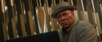 Movie still from “Mission: Impossible - Dead Reckoning Part One” (2023), directed by Christopher McQuarrie – An older man wearing a hat looking at a computer screen; Close Up shot, Low angle