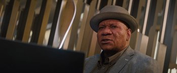 Movie still from “Mission: Impossible - Dead Reckoning Part One” (2023), directed by Christopher McQuarrie – An older man wearing a hat looking at a computer screen; Close Up shot, Low angle