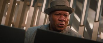 Movie still from “Mission: Impossible - Dead Reckoning Part One” (2023), directed by Christopher McQuarrie – An older man wearing a hat looking at a computer screen; Close Up shot, Low angle