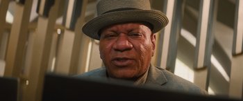 Movie still from “Mission: Impossible - Dead Reckoning Part One” (2023), directed by Christopher McQuarrie – An older man wearing a hat looking at a laptop; Close Up shot, Low angle