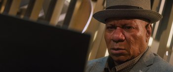 Movie still from “Mission: Impossible - Dead Reckoning Part One” (2023), directed by Christopher McQuarrie – An older man wearing a hat looking at a computer screen; Close Up shot, Low angle