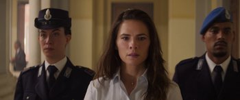 Movie still from “Mission: Impossible - Dead Reckoning Part One” (2023), directed by Christopher McQuarrie – A woman in a white dress shirt is looking at the camera; Close Up shot, Over the shoulder angle