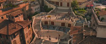 Movie still from “Mission: Impossible - Dead Reckoning Part One” (2023), directed by Christopher McQuarrie – An aerial view of people walking around a building; Extreme Wide shot, High angle