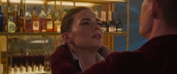 Movie still from “Mission: Impossible - Dead Reckoning Part One” (2023), directed by Christopher McQuarrie – A beautiful young lady sitting in front of a bar; Close Up shot, Over the shoulder angle