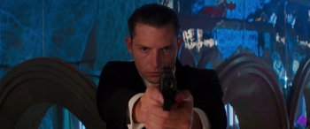 Movie still from “Mission: Impossible - Dead Reckoning Part One” (2023), directed by Christopher McQuarrie – A man in a suit and tie holding a gun in his hand; Close Up shot, Low angle