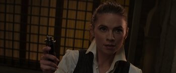 Movie still from “Mission: Impossible - Dead Reckoning Part One” (2023), directed by Christopher McQuarrie – A woman holding a cell phone while wearing a vest; Close Up shot, Over the shoulder angle