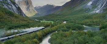 Movie still from “Mission: Impossible - Dead Reckoning Part One” (2023), directed by Christopher McQuarrie – A train traveling down tracks next to a river; Extreme Wide shot, High angle