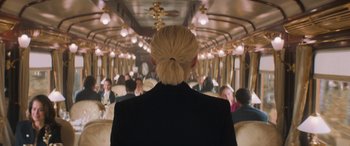 Movie still from “Mission: Impossible - Dead Reckoning Part One” (2023), directed by Christopher McQuarrie – A woman in a black jacket is standing on a train; Close Up shot, Over the shoulder angle
