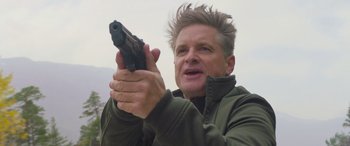 Movie still from “Mission: Impossible - Dead Reckoning Part One” (2023), directed by Christopher McQuarrie – A man holding a gun in his hands; Close Up shot, Low angle