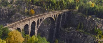 Movie still from “Mission: Impossible - Dead Reckoning Part One” (2023), directed by Christopher McQuarrie – A painting of a bridge over a river with trees in the background; Extreme Wide shot, High angle