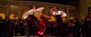 Movie still from “Mission: Impossible II” (2000), directed by John Woo – A group of people dancing on a stage; Wide shot, Low angle