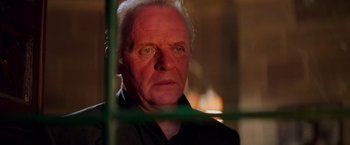 Movie still from “Mission: Impossible II” (2000), directed by John Woo – A person looking through a fence; Close Up shot, Low angle