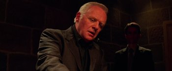 Movie still from “Mission: Impossible II” (2000), directed by John Woo – A person wearing a suit and tie; Close Up shot, Low angle