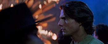 Movie still from “Mission: Impossible II” (2000), directed by John Woo – A man's face in front of fireworks; Close Up shot, Over the shoulder angle