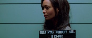 Movie still from “Mission: Impossible II” (2000), directed by John Woo – A woman holding up a black and white sign; Close Up shot, Overhead angle