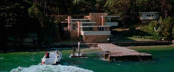 Movie still from “Mission: Impossible II” (2000), directed by John Woo – A man standing on a surfboard next to a boat; Extreme Wide shot, High angle