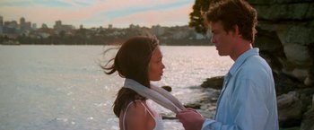 Movie still from “Mission: Impossible II” (2000), directed by John Woo – A man tying a woman's neck tie by the water; Medium shot, Over the shoulder angle