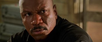 Movie still from “Mission: Impossible II” (2000), directed by John Woo – A man's face with a black shirt on; Close Up shot, Low angle