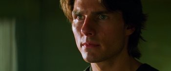 Movie still from “Mission: Impossible II” (2000), directed by John Woo – A man's face in a dark room; Close Up shot, Low angle