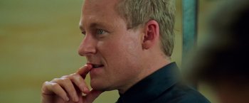 Movie still from “Mission: Impossible II” (2000), directed by John Woo – A person with his hand to his face; Close Up shot, Over the shoulder angle