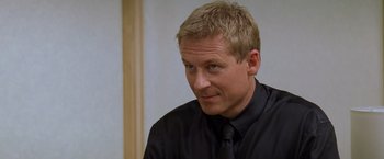 Movie still from “Mission: Impossible II” (2000), directed by John Woo – A person wearing a shirt and tie; Close Up shot, Over the shoulder angle