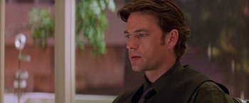 Movie still from “Mission: Impossible II” (2000), directed by John Woo – A person wearing a suit and tie; Close Up shot, Over the shoulder angle