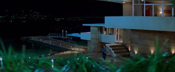 Movie still from “Mission: Impossible II” (2000), directed by John Woo – A woman walking down the steps of a house; Extreme Wide shot, High angle